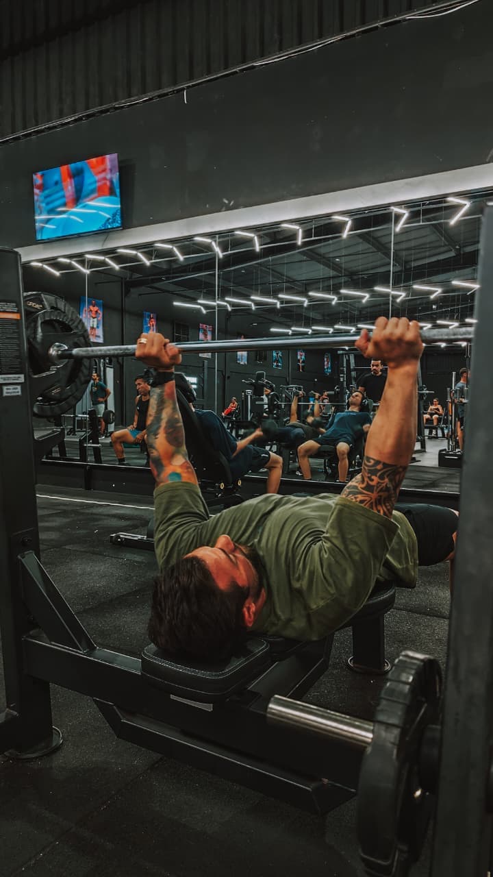 Aluno fazendo supino na área de peso livre do CT Forma Fit